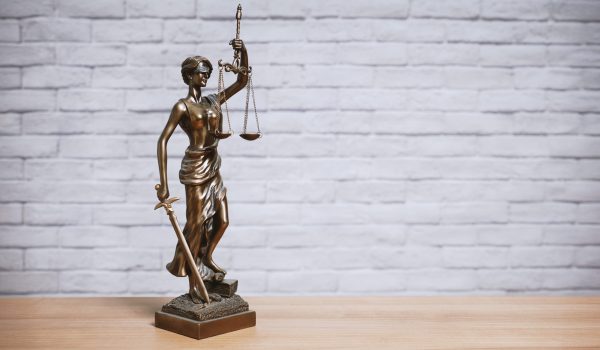Lady Justice or Justitia the goddess of justice statue on desk - legal law legislation concept
